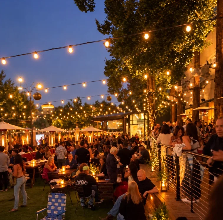 Singles mingling on a string-lit outdoor patio at dusk